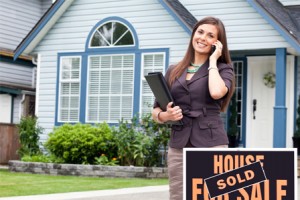 real-estate-agent-in-front-of-sold-home
