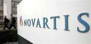 People walk past the logo of Swiss drugmaker Novartis at the company's plant in Basel